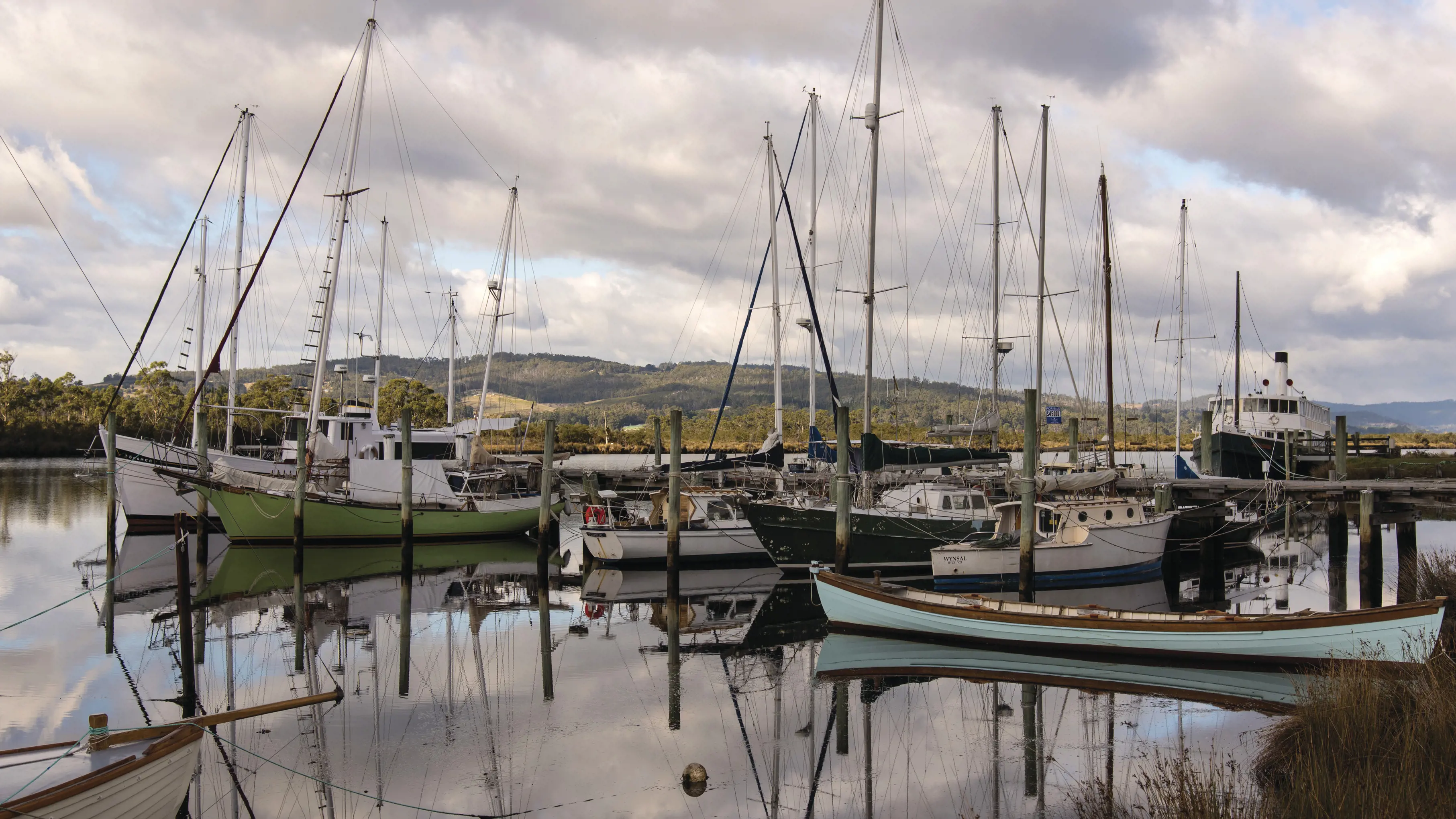 The quaint down of Franklin, fishing boats float on the water, reflecting on the glossy, mirror-like lake.   
