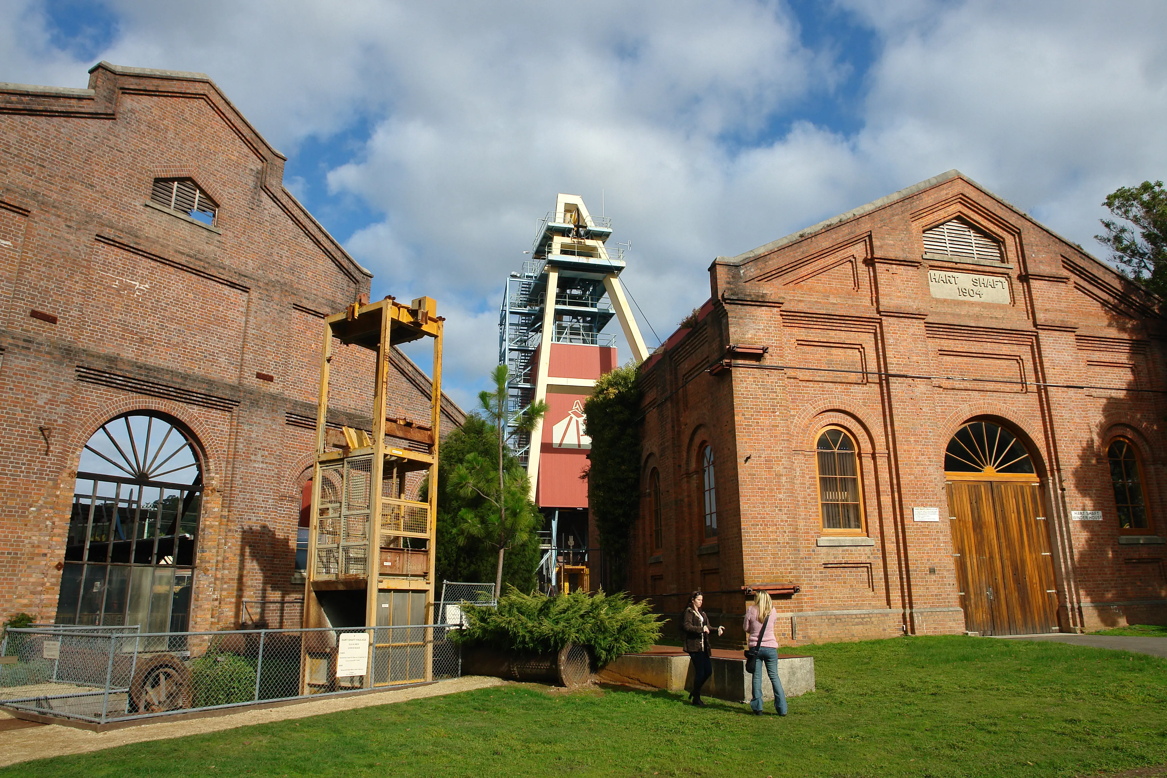 The exterior of two imposing heritage red-brick industrial buildings, renovated as museums.