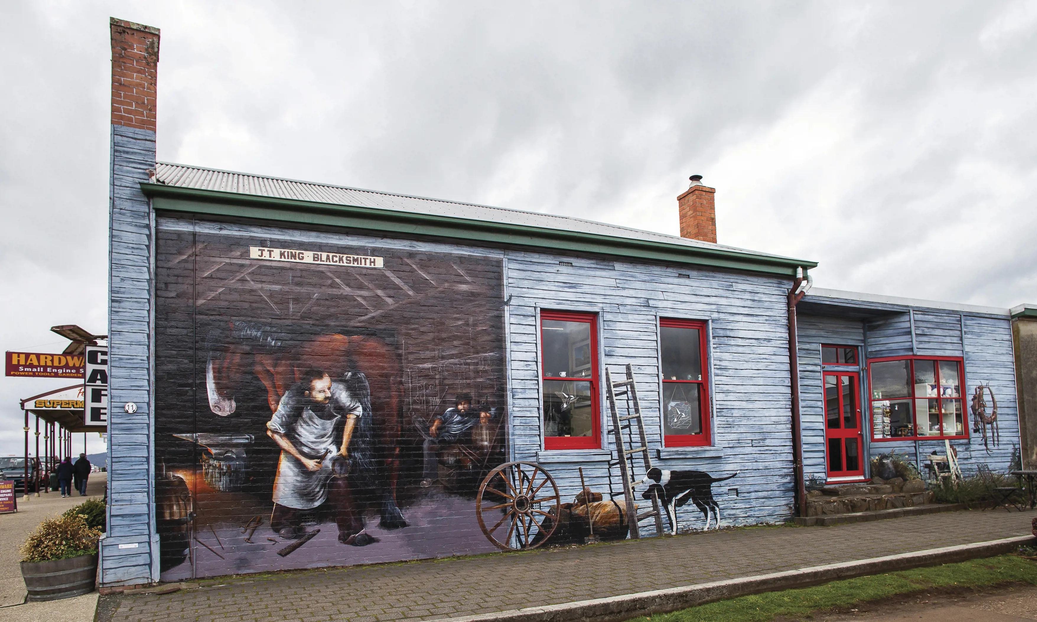 Detailed mural of a man fixing a horseshoe on a horse. The history of the region has been painted on almost every blank wall throughout town.