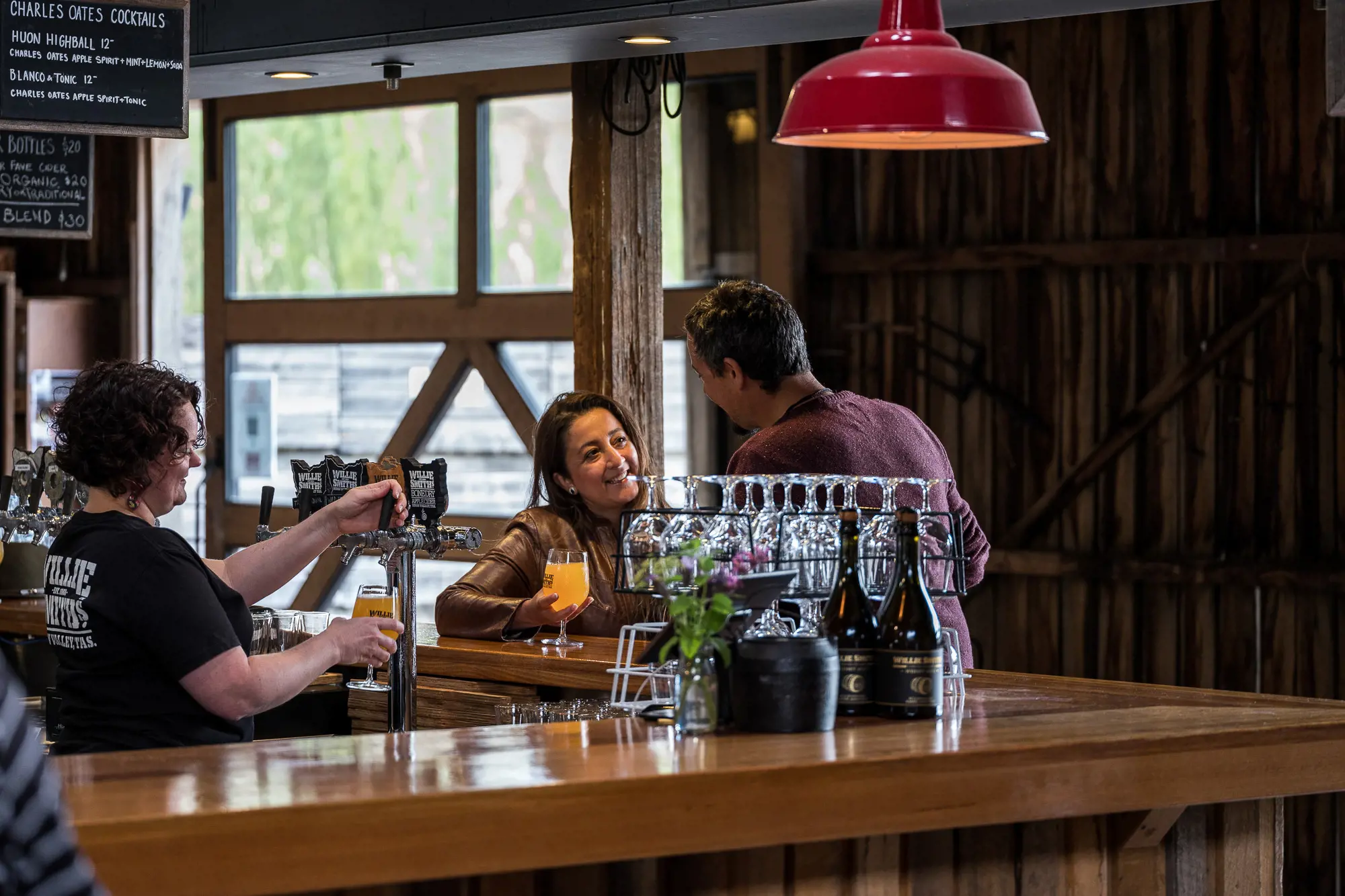 Friends talk and sample cider at the bar in Willie Smiths Apple Shed
